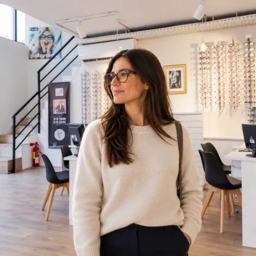 Mujer con gafas graduadas y lentes antirreflejantes en el interior de Óptica Llevot en Cornellà.