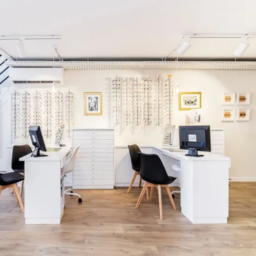 Interior de Óptica Llevot en Cornellà con expositores de monturas de gafas graduadas y zona de atención personalizada.